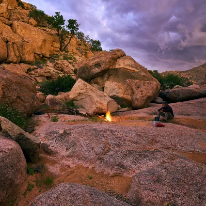A documentary study of the artist on a solitary vigil; capturing a moment of quiet preparation amidst the high-altitude isolation of Namibia's northern desert frontiers.