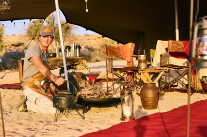 Authentic hospitality in the field, showing the deliberate care and culinary precision involved in a Divine Namibia expedition.