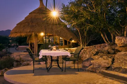 The outdoor dining terrace, highlighting a curated hospitality experience overlooking the vast, sun-drenched plains.