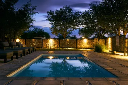 The lodge swimming pool, a secluded oasis framed by the indigenous Mopane woodland of the Omusati region.