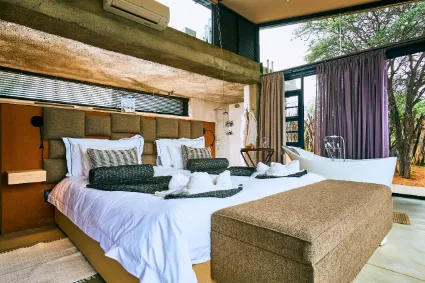 A spacious luxury villa at Otjimbondona, showcasing the sophisticated design and expansive glass walls that invite the Kalahari landscape inside.