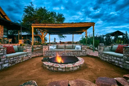 The central fire pit at the Manor House, a structural social space designed for reflection under the unfiltered African night sky.
