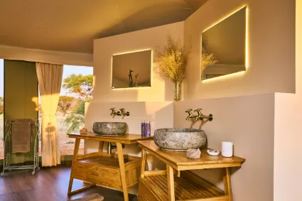 The interior of a luxury safari tent, where canvas walls and refined furnishings create an intimate, tactile connection with the wilderness.