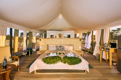 A perspective of the open-plan tent layout, highlighting the seamless flow between the sleeping quarters and the natural environment.