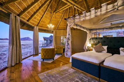 The refined interior of a standard guest suite, where minimalist architecture provides a quiet frame for the vast desert plains outside.