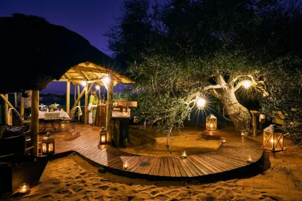 The intimate dining space of the luxury camp, documenting a refined hospitality setting designed for privacy and wilderness immersion.