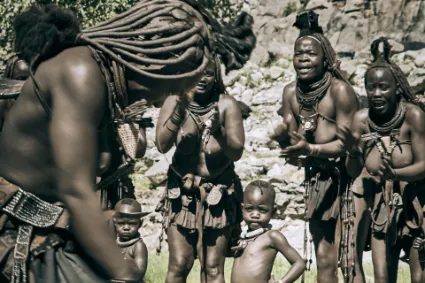 A group of Himba women participating in a traditional circle dance, a celebration of community and cultural continuity.