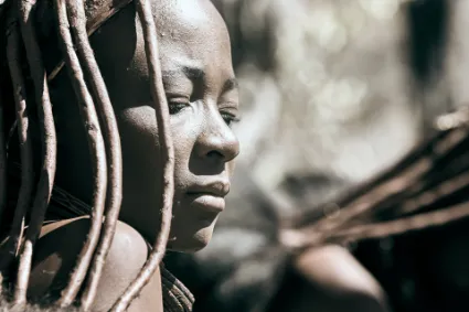 A portrait of a Himba woman in customary attire, highlighting the dignity and poise of those who choose to evade the 'modern mirage'.