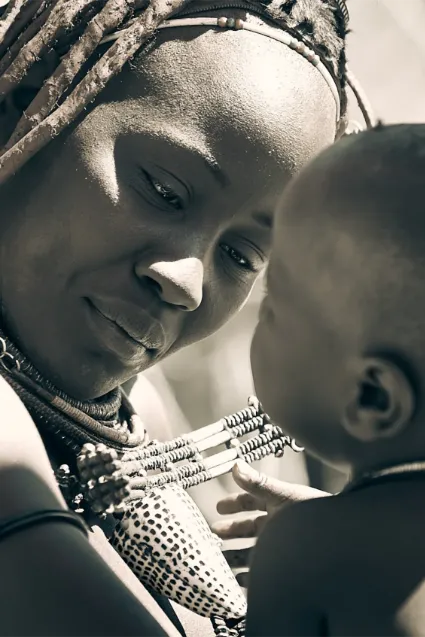 An intimate portrait of a Himba mother looking at her child, capturing a universal moment of affection within a deeply traditional Namibian heritage.