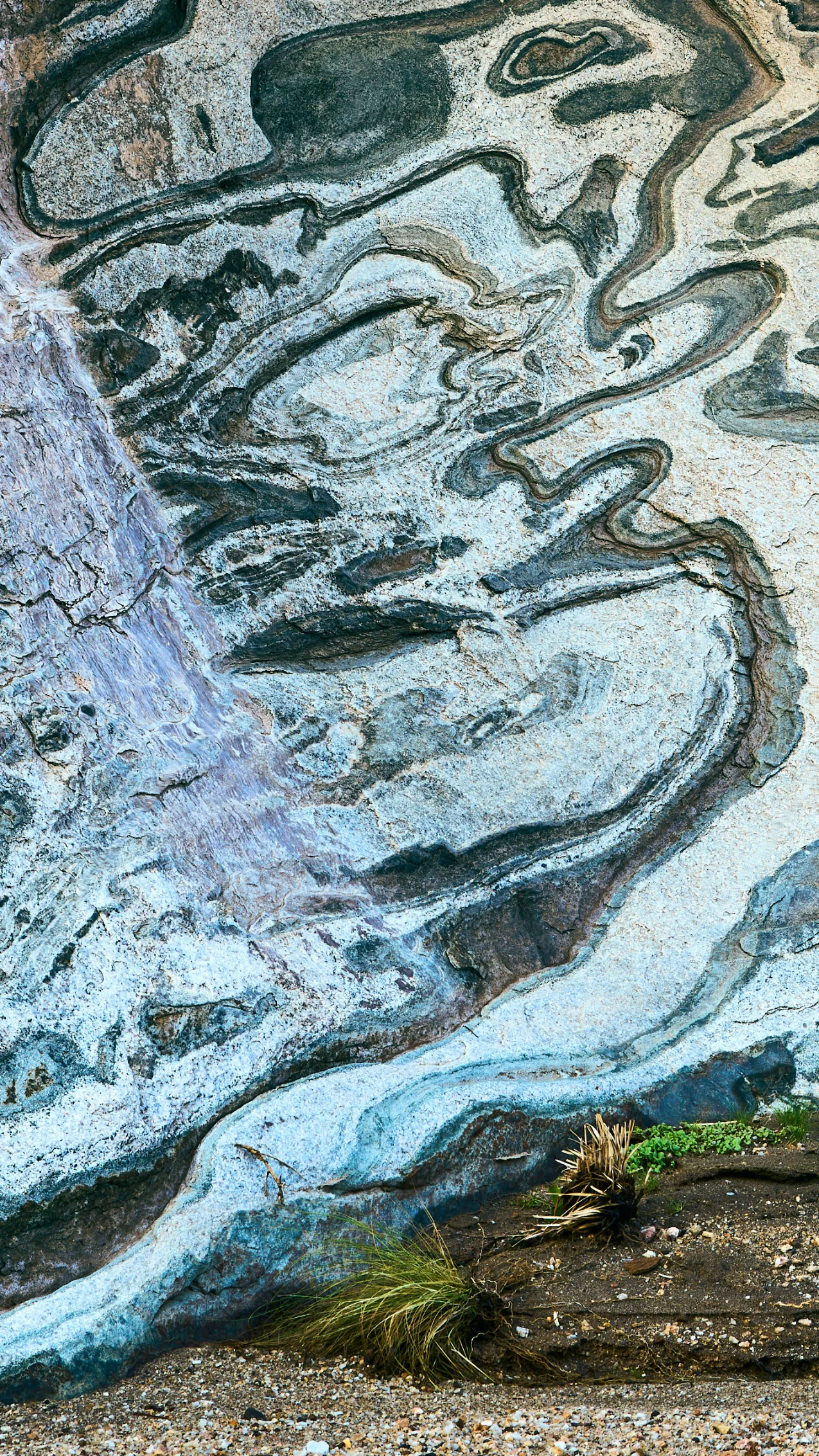 A geological study of warped sediment bands in a remote Namibian enclave; Nature's Aztec lines whispering the world's history through morphed stone layers far from the tourist trail.