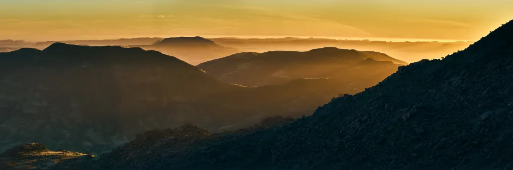 An expansive panoramic vista from the mouth of Ammis Gorge on the western periphery of the Brandberg Massif, overlooking the ancient, sun-weathered plains of the Namib.