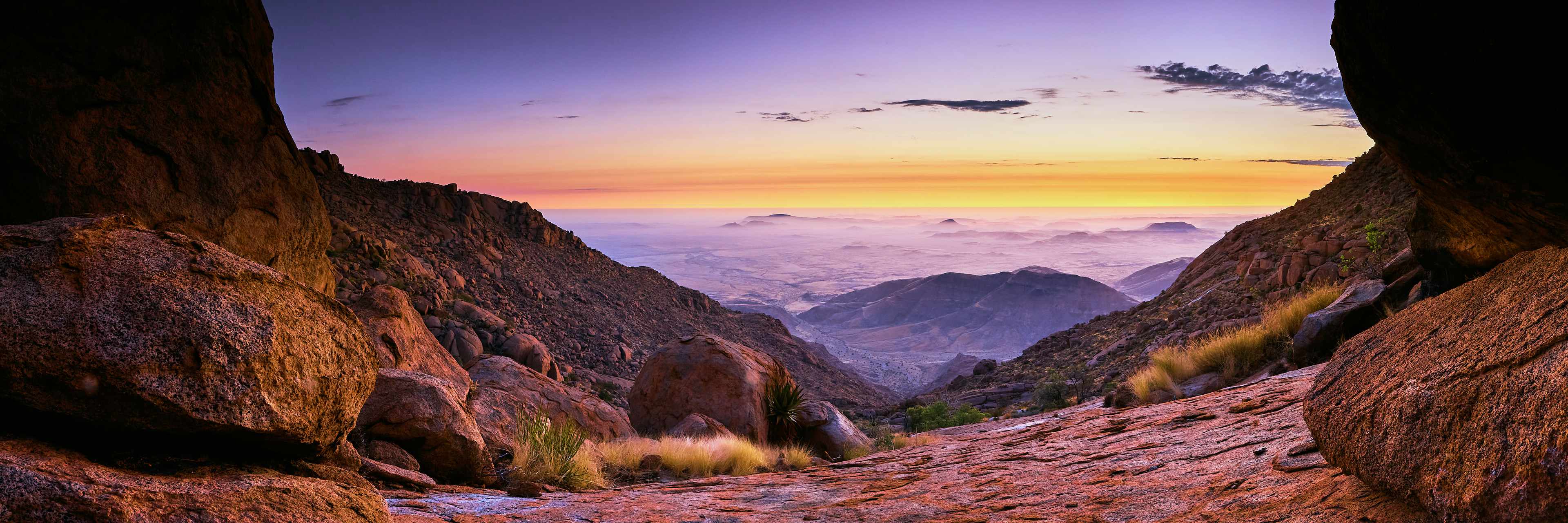 Sunset view from Ammies Gauge, capturing the serene coastal plains from Brandberg's elevated pearch under a vibrant sky.