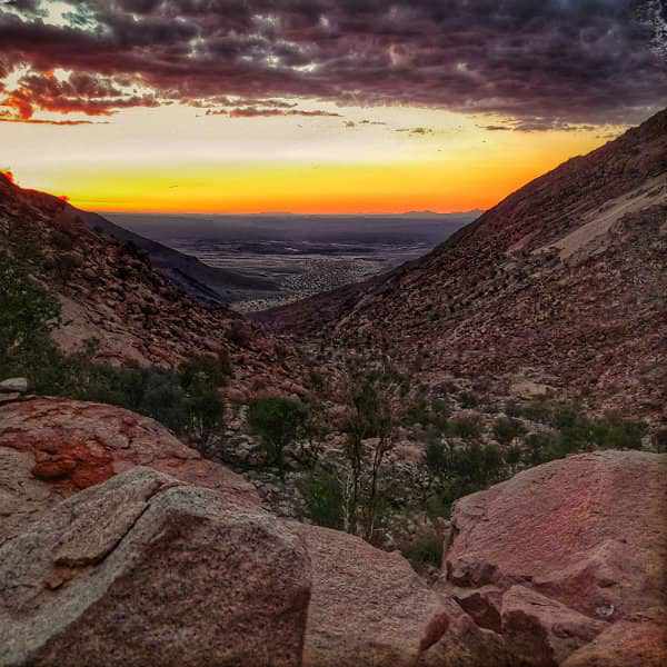 Sunset view of the Niab Gauge valley surrounded by the majestic Brandberg mountains, under a vibrant sky.