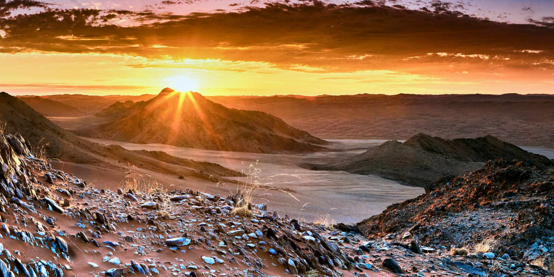 Golden sunset illuminating the rugged landscape of White Mountain, near Deadvlei in the Sossusvlei region, showcasing the serene beauty of the Namib Desert.