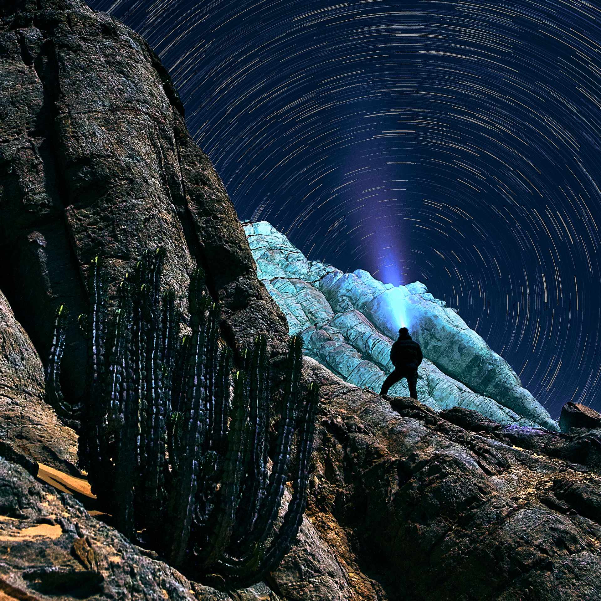 Starry Night Over Rossing Mountain: A mesmerizing astro photograph capturing the swirling star trails and a silhouetted figure against the rugged terrain of Rossing Mountain, embodying the harmony between earth and cosmos.