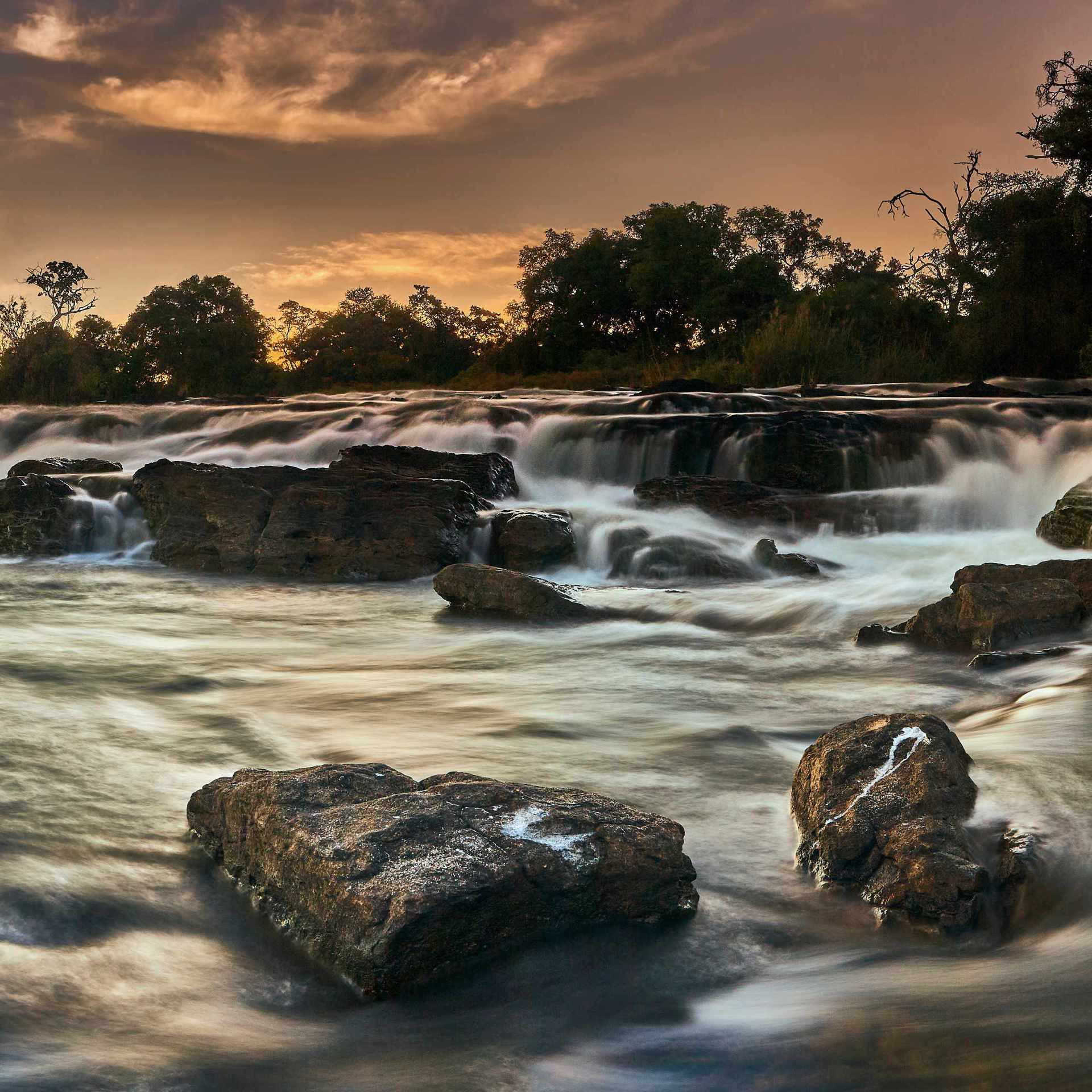 Photograph of the rapids at Poppa Falls in the Caprivi region of Northern Namibia, showcasing the dynamic movement of water in the natural landscape.